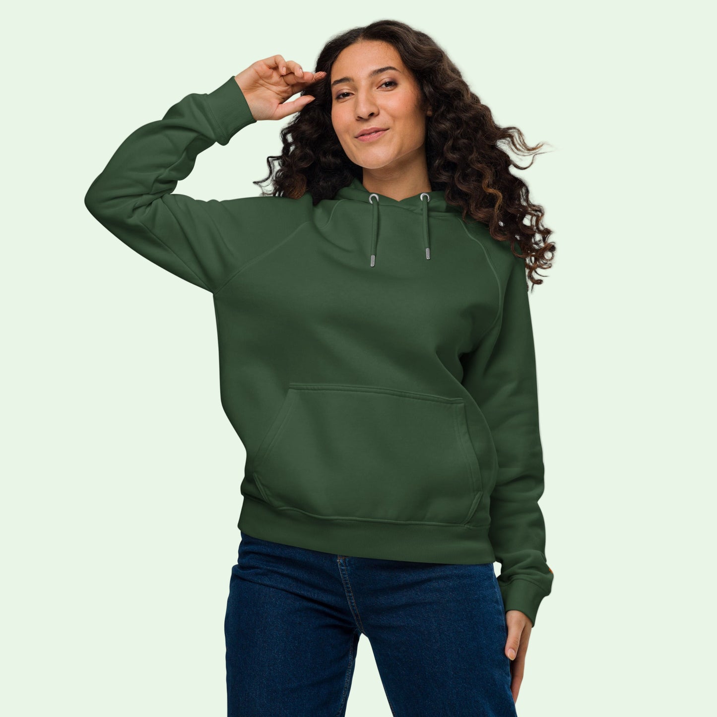 woman wearing an unisex eco ranglan hoodie in bottle green front view by Aunti