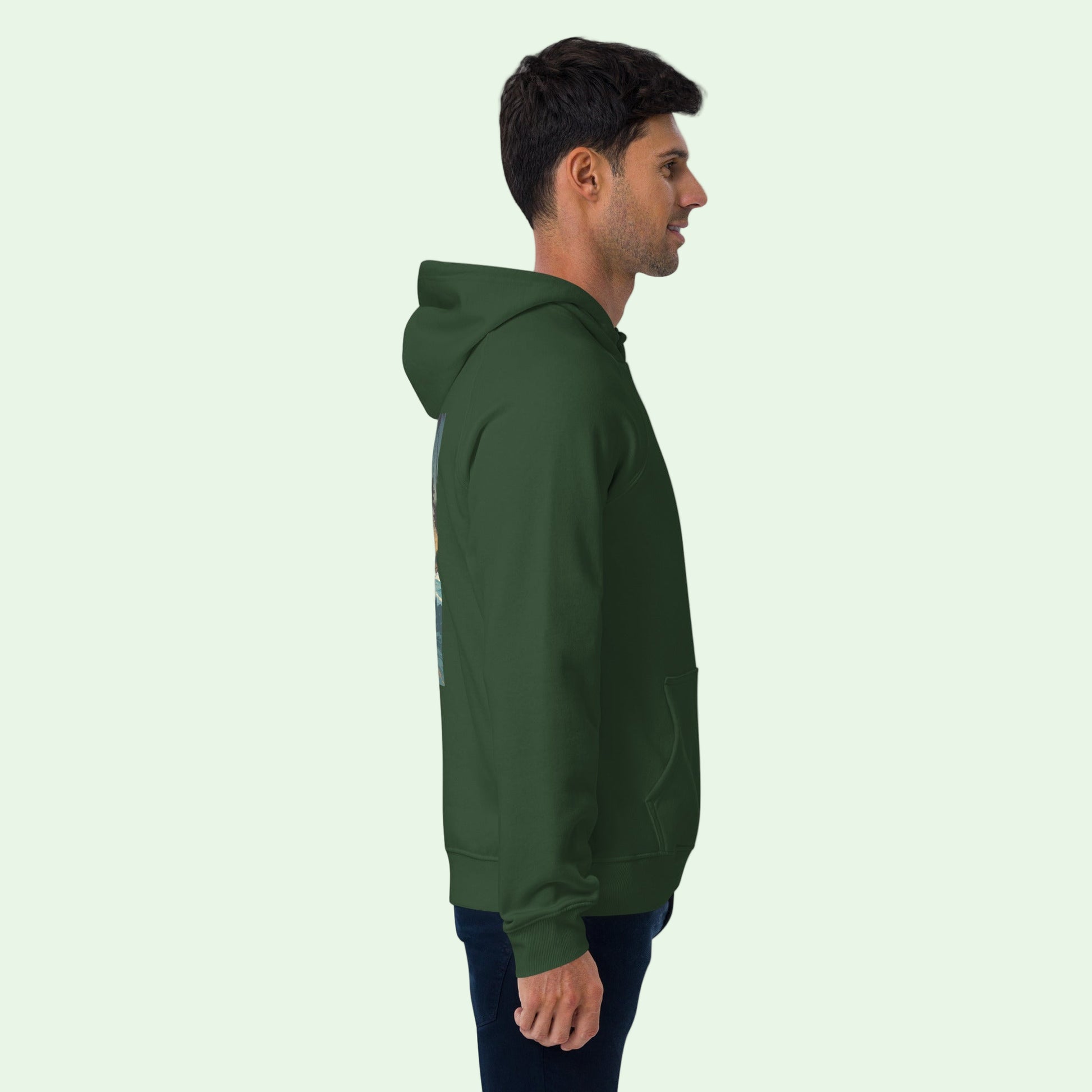 a man wearing an unisex eco ranglan hoodie in bottle green by Aunti  right view