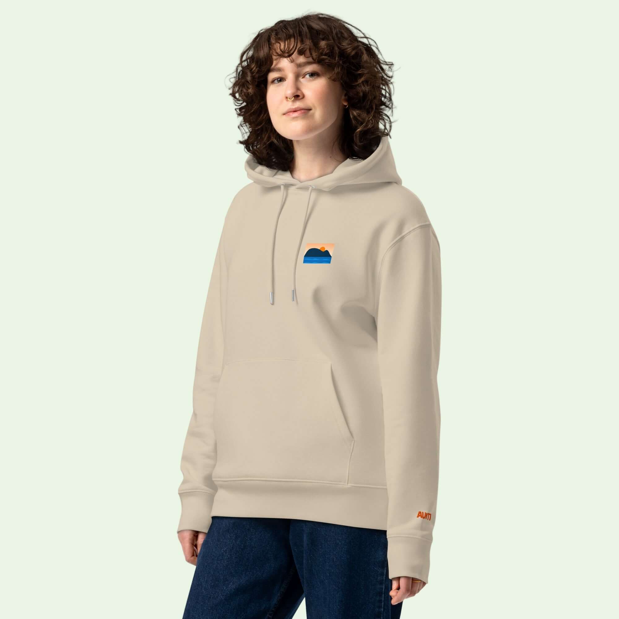 woman wearing an unisex gots eco hoodie in desert dust with Mouse of Getaria design on left chest by Aunti